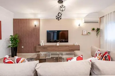 a living room with a couch and a tv at Moderne, 2 CH, Fibre optique, AC Garage Ascenseur in Rabat