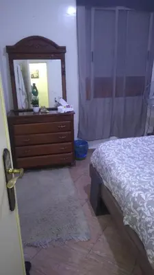 a bedroom with a bed and a dresser with a mirror at Belle chambre sidi maarouf in Casablanca