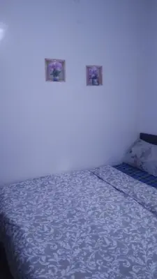 a bedroom with a bed with a blue blanket at Belle chambre sidi maarouf in Casablanca