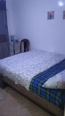 a bed with a blue and white comforter in a room at Belle chambre sidi maarouf in Casablanca