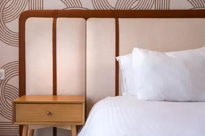 a bed with a white pillow and a wooden nightstand at LuxArt Casablanca in Casablanca