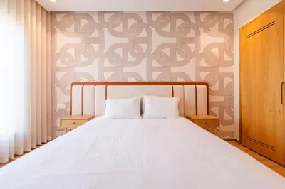 a bedroom with a white bed with a patterned wall at LuxArt Casablanca in Casablanca
