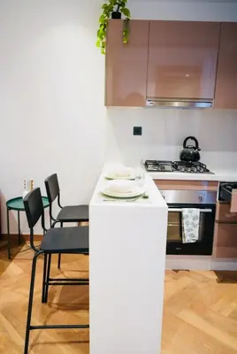 a small kitchen with a white counter and chairs at Les princesses studio confortable in Maarif