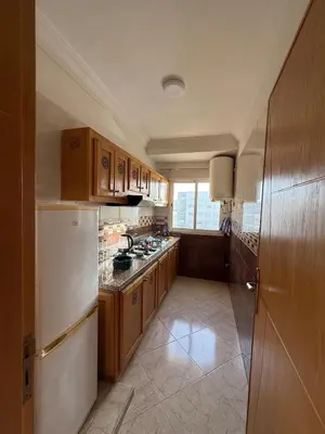 a kitchen with wooden cabinets and a white refrigerator at Charming 1 bedroom apartment Ocean living room, Rabat in Rabat