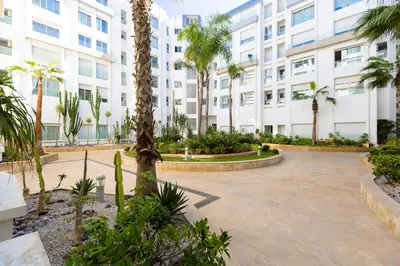 a courtyard with palm trees in front of a building at Luxury Duplex with Home Cinema Central Casablanca in Casablanca