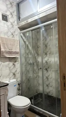 a bathroom with a toilet and a glass shower at Cozy Sunny Apartment Near Beach nd Local Amenities in Dar Ben Abdallah Ben Dehbi
