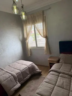 a bedroom with two beds next to a window at Cozy Sunny Apartment Near Beach nd Local Amenities in Dar Ben Abdallah Ben Dehbi