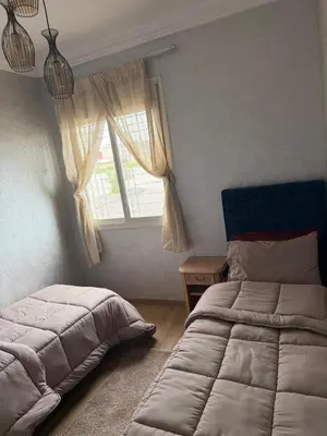 a bedroom with two beds and a window at Cozy Sunny Apartment Near Beach nd Local Amenities in Dar Ben Abdallah Ben Dehbi