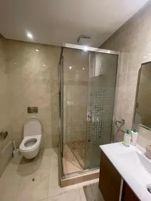 a bathroom with a shower and a toilet and a sink at Prestigia appartement in Rabat