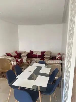 a room with a table and chairs and a couch at Prestigia appartement in Rabat