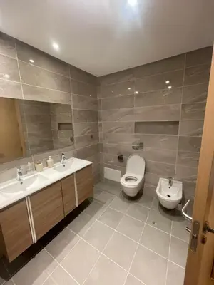 a bathroom with two sinks and a toilet at Prestigia appartement in Rabat