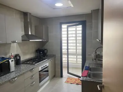 a kitchen with a sink and a stove at Prestigia appartement in Rabat