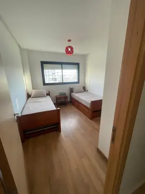 a room with two beds and a window at Prestigia appartement in Rabat