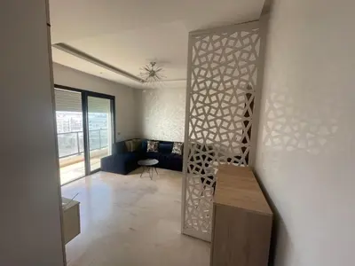 a living room with a couch and a wall with a partition at Prestigia appartement in Rabat