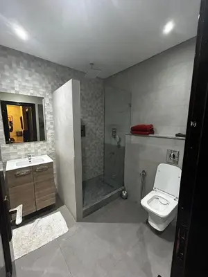 a bathroom with a shower and a toilet and a sink at Cozy Apt Near Train Station in Rabat