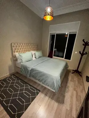 a bedroom with a bed and a large window at Cozy Apt Near Train Station in Rabat