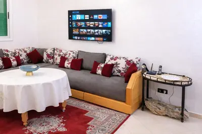a living room with a couch and a table at Spacious Family-Friendly Apartment in Temara