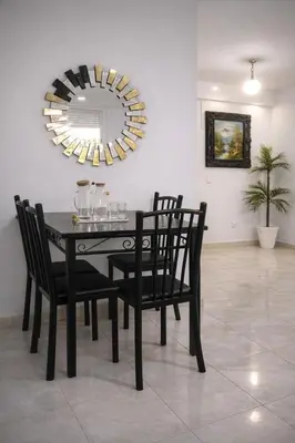 a black dining room table with chairs and a mirror at appart a 5min de l'hôpital Mohamed 6 in Casablanca