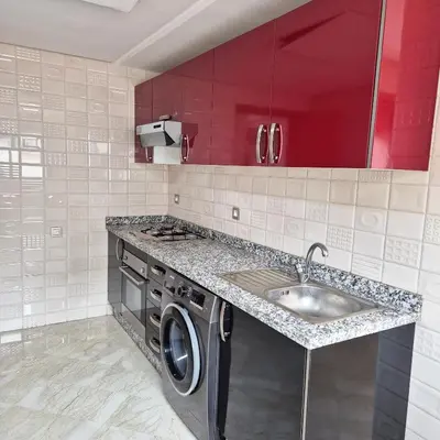 a kitchen with a sink and a washing machine at Appartement familial au quartier des Hôpitaux in Casablanca