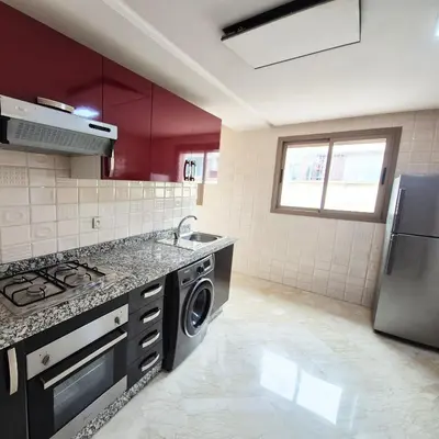 a kitchen with a sink and a stove top oven at Appartement familial au quartier des Hôpitaux in Casablanca