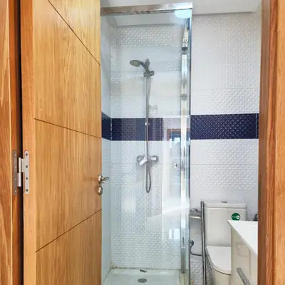 a bathroom with a shower with a glass door at Appartement familial au quartier des Hôpitaux in Casablanca
