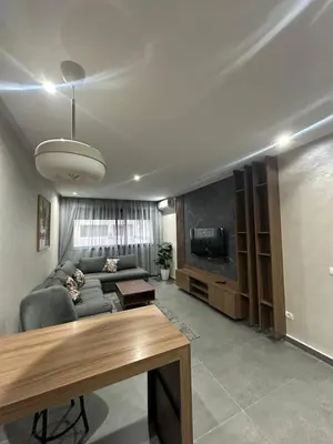 a living room with a couch and a tv at Residence Carlton House2 STUDIOS in Roches Noires