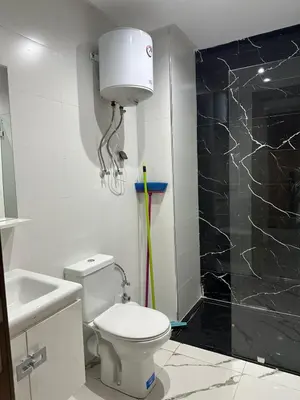 a bathroom with a white toilet and a shower at Residence Carlton House2 STUDIOS in Roches Noires