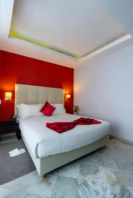 a bedroom with a white bed with a red wall at The Fourteen Luxury Boutique Hotel & SPA in Casablanca