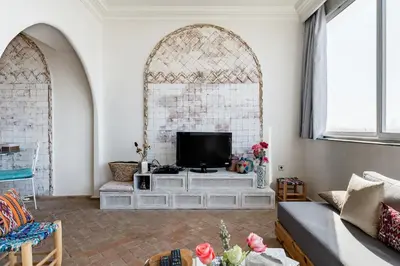 a living room with a tv on a white wall at Charming Moroccan Studio, Breathtaking View in Casablanca
