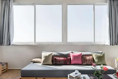 a couch in a room with three windows at Charming Moroccan Studio, Breathtaking View in Casablanca