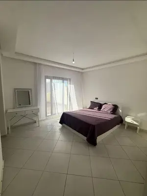 a bedroom with a bed and a large window at Apartment avec piscine terrasse et balcon in Bouznika