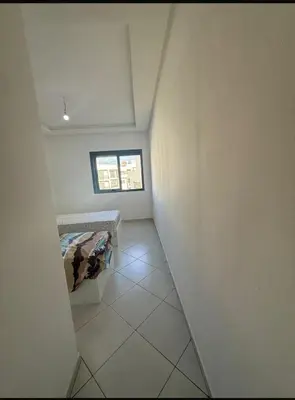 a hallway of a room with a bed and a window at Apartment avec piscine terrasse et balcon in Bouznika