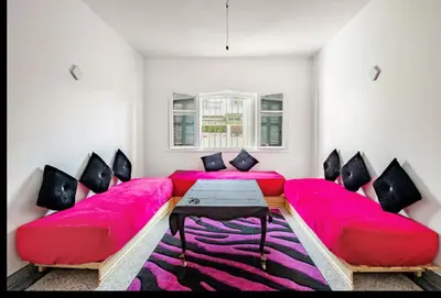 a living room with a red couch and a table at Villa à harhora in Temara