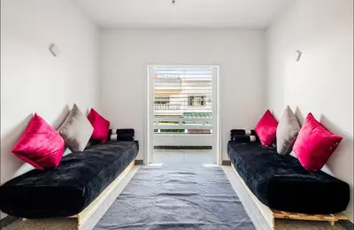 a living room with two black couches with pink pillows at Villa à harhora in Temara