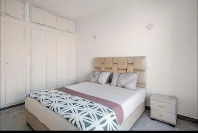 a bedroom with a bed and a night stand at Villa à harhora in Temara
