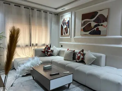 a living room with a white couch and a coffee table at Evasion chic et central au coeur de Maarif in Casablanca