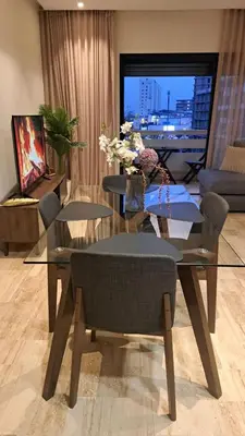 a living room with a glass table and chairs at Luxury Appart Finance City in Casablanca