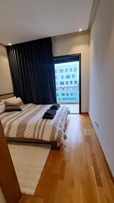 a bedroom with a bed and a large window at Luxury Appart Finance City in Casablanca