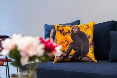 a monkey pillow on a blue couch with flowers at Luxury one bedroom in Triangle d'or with rooftop pool in Casablanca