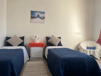a room with two beds with blue comforters at Chambre Cosy - Accès Côte et Plage Mohammedia, Centre-Ville Mohammedia à Pied - Résidence 3 Mars in Mohammedia