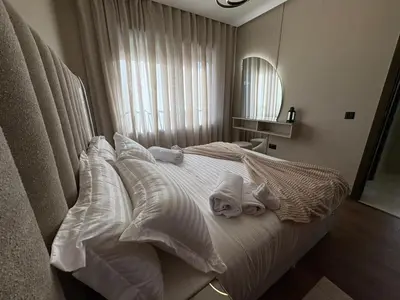 a bedroom with a white bed with towels on it at Premium Studio Oasis Secure Parking High Speed Fiber Wifi Luxoria Oasis Residence Near CFC & 70p Smart TV in Casablanca