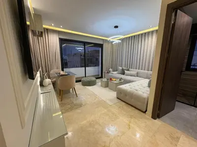 a living room with a couch and a table at Premium Studio Oasis Secure Parking High Speed Fiber Wifi Luxoria Oasis Residence Near CFC & 70p Smart TV in Casablanca