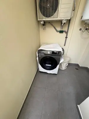 a room with a washing machine in the corner of a room at Premium 2 Bedroom Suite Maarif Central & High-Speed Wi-Fi Fully Equipped Walk to Twin Center & Shops Next to Carrefour Val Fleuri Family-Friendly in Casablanca