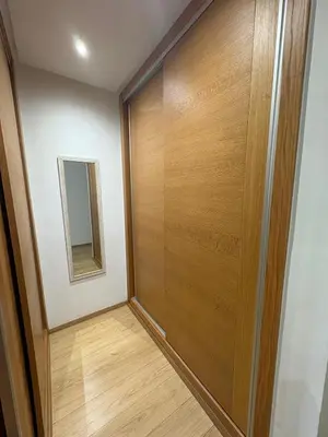 a hallway with a wooden door and a mirror at Premium 2 Bedroom Suite Maarif Central & High-Speed Wi-Fi Fully Equipped Walk to Twin Center & Shops Next to Carrefour Val Fleuri Family-Friendly in Casablanca