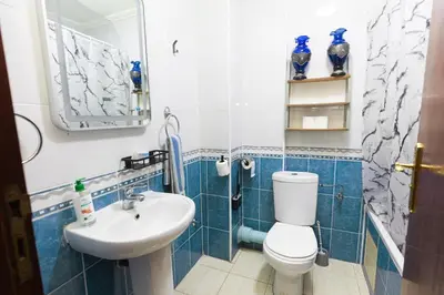a blue and white bathroom with a toilet and a sink at Apartement complets pres Ocean port de Casablanca in Casablanca