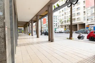 an empty sidewalk with columns on a city street at Apartement complets pres Ocean port de Casablanca in Casablanca