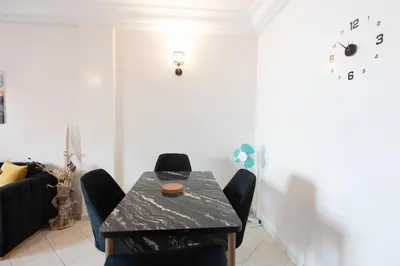 a dining room with a black table and chairs at Apartement complets pres Ocean port de Casablanca in Casablanca