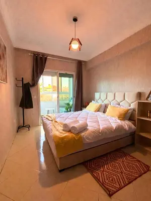 a large bed in a bedroom with a window at Charming apartment near Mohammedia station in Mohammedia