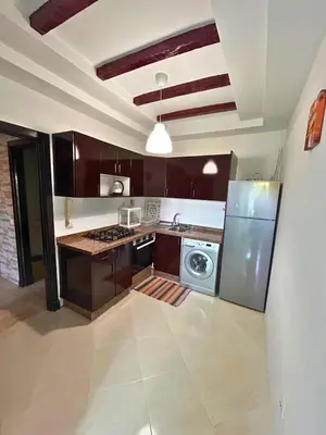 a kitchen with a refrigerator and a washer and dryer at Charming apartment near Mohammedia station in Mohammedia