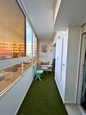 a living room with a large window and green carpet at Charming apartment near Mohammedia station in Mohammedia